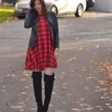 Robe à carreaux rouge en combinaison avec des cuissardes et une veste en cuir