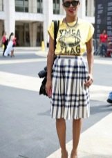 Below the knee check skirt paired with a bright T-shirt