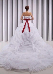 Robe de mariée luxuriante avec une traîne et un nœud rouge