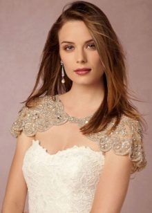 White sheath wedding dress combined with a beige lace cape on the shoulders