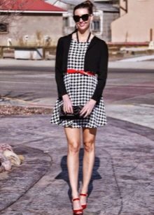 Robe pied-de-poule associée à des accessoires rouges et un cardigan noir