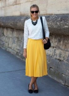 Below the knee yellow skirt in combination with a white blouse