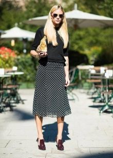 A skirt with a small print below the knee in combination with a plain sweatshirt