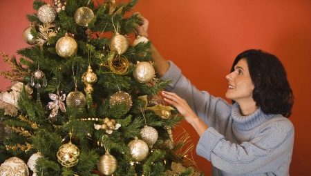 Decorating the Christmas tree with golden toys