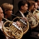 What is a French horn and how is it played?