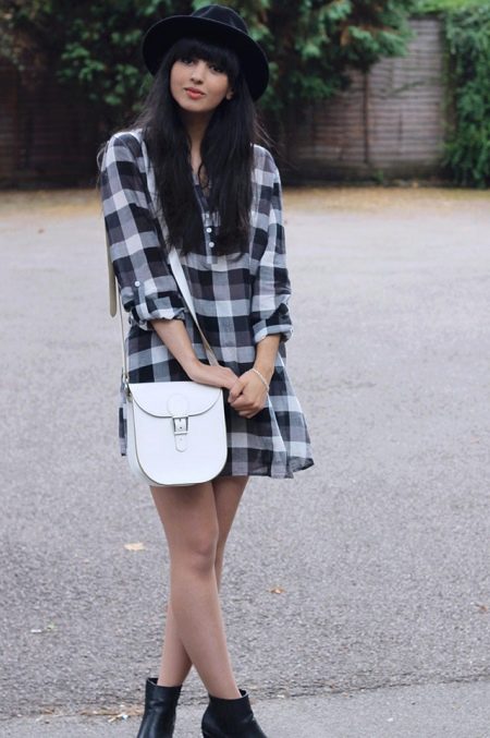 Robe chemise à carreaux en combinaison avec un sac à bandoulière blanc, des bottes noires et un chapeau